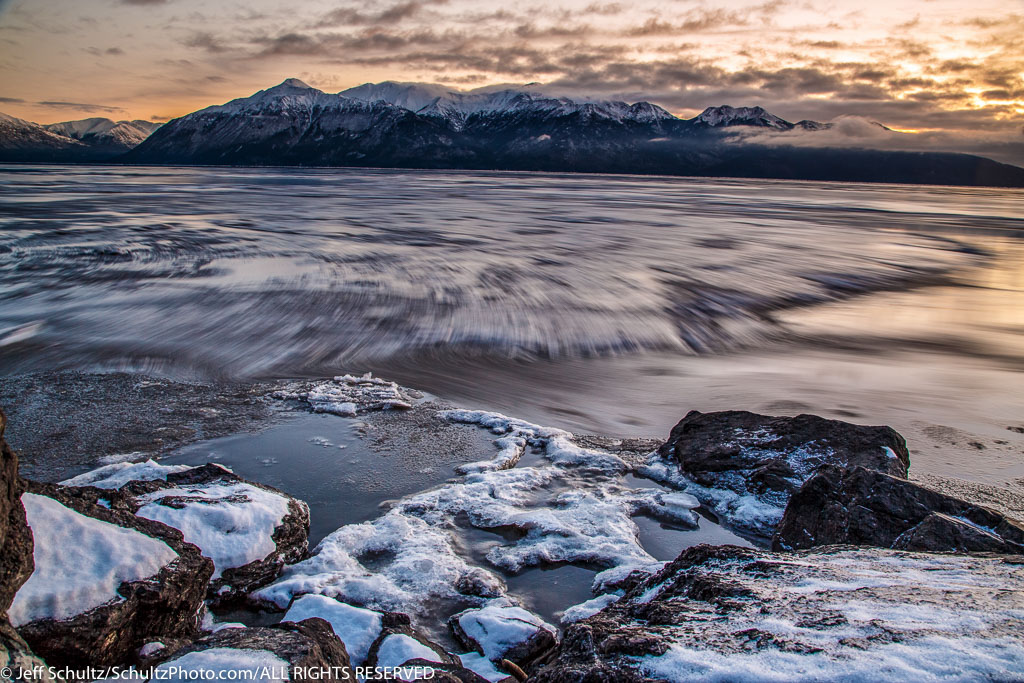 Winter landscape of cce sheets move along the outgoing tide of Turnagain Arm after sunset. December, 2015