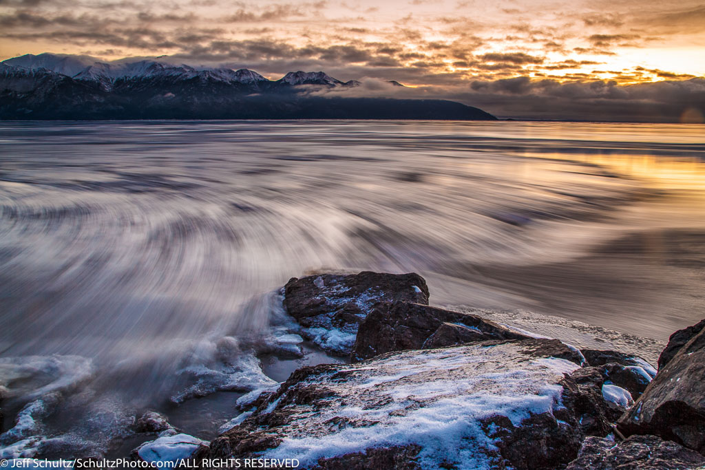 Winter landscape of ice sheets move along the outgoing tide of Turnagain Arm after sunset. December, 2015